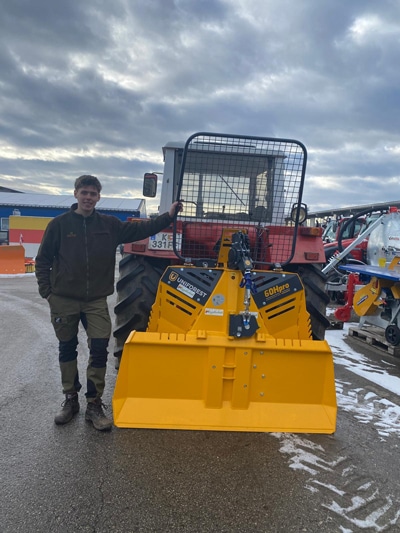 Traktor mit Uniforest 60Hpro Seilwinde, gelbes Forst-Anbaugerät auf dem Hof