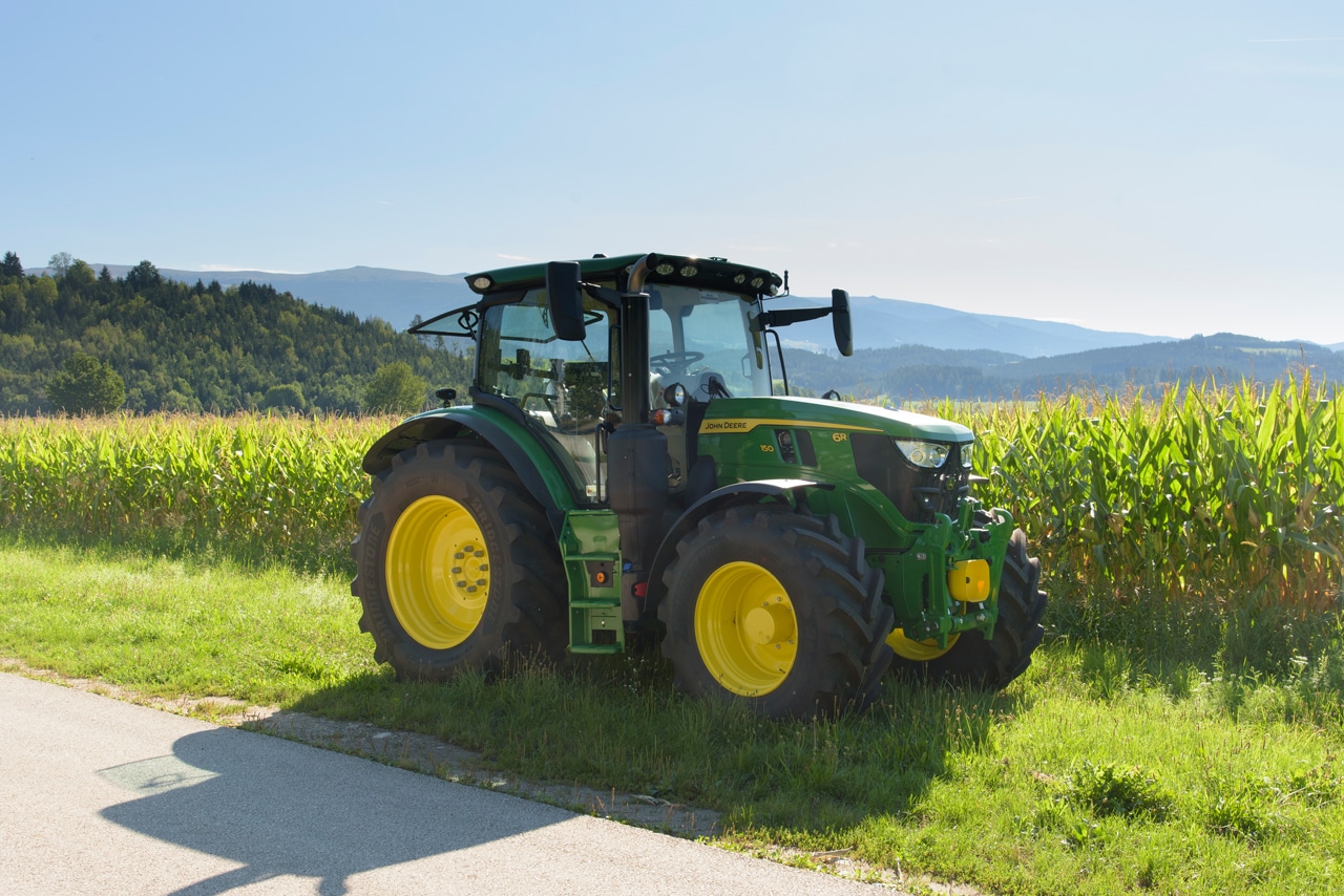 John Deere Traktor John Deere Traktor vor einem Maisacker
