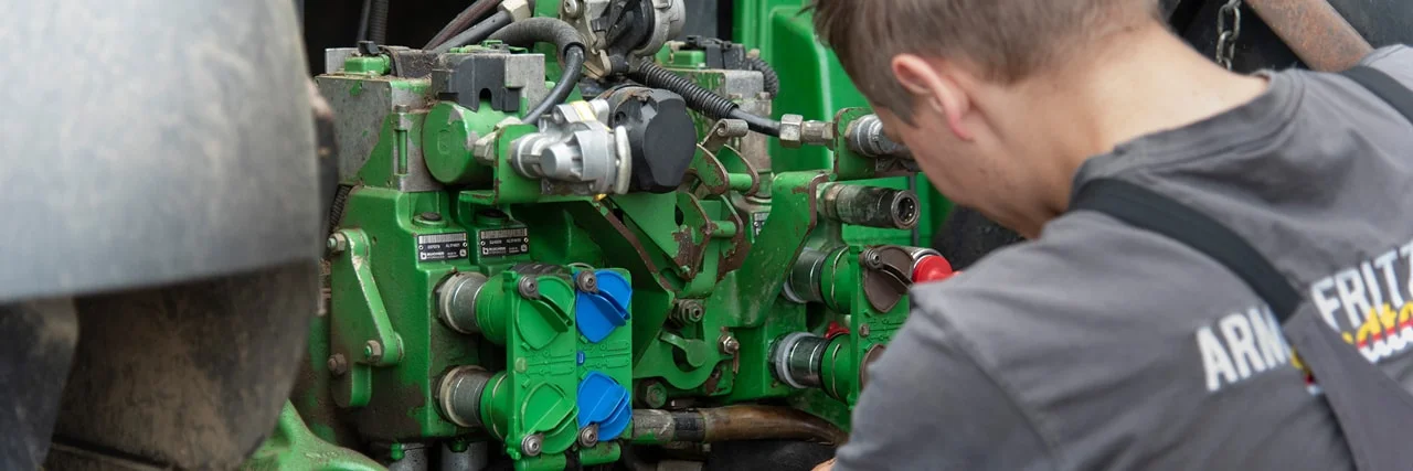 Ein Landmaschinentechniker bei der Arbeit an einem Traktor
